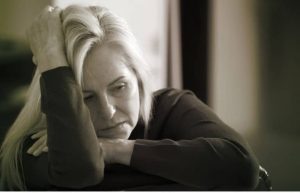 Gray and white photo of a depressed middle-aged woman